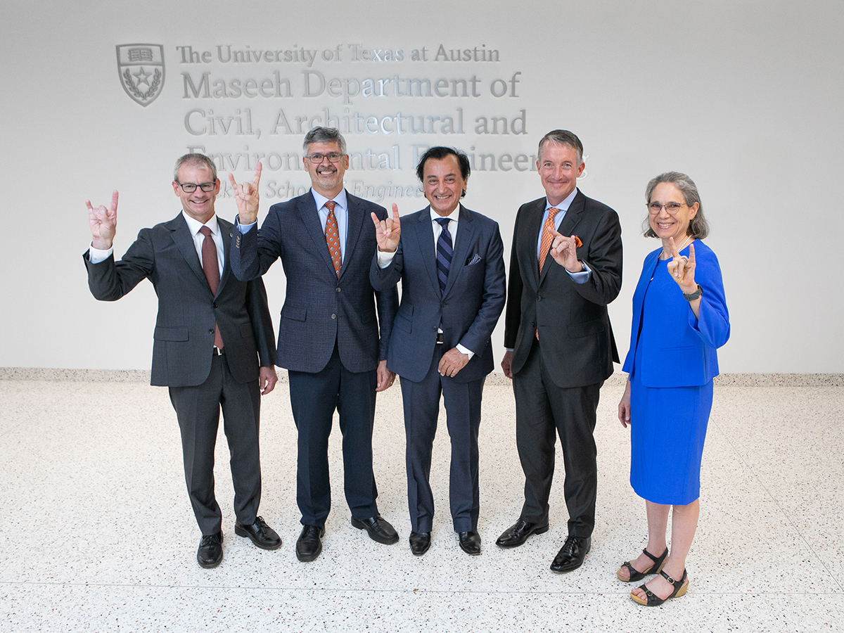 group standing in front of department sign with hook 'em hand