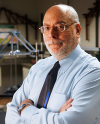 Texas CAEE alumnus José Holguín-Veras with arms crossed in lab