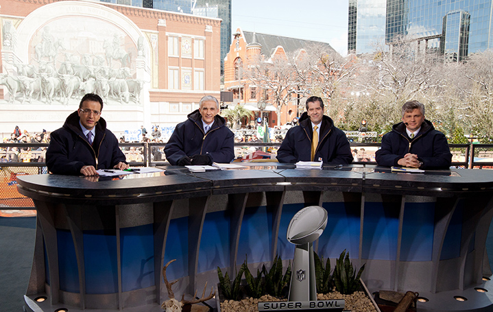 Four men sitting at podium during superbowl