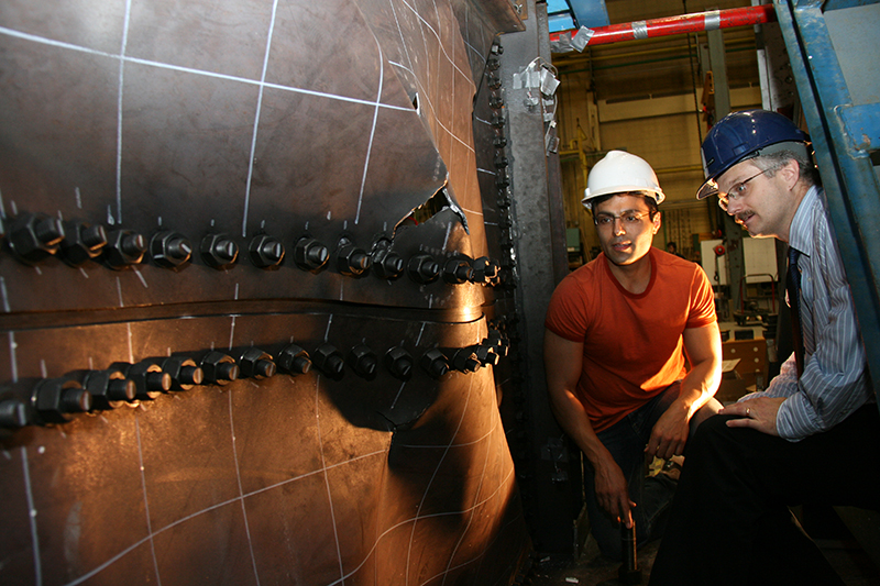 two people inspecting broken structure