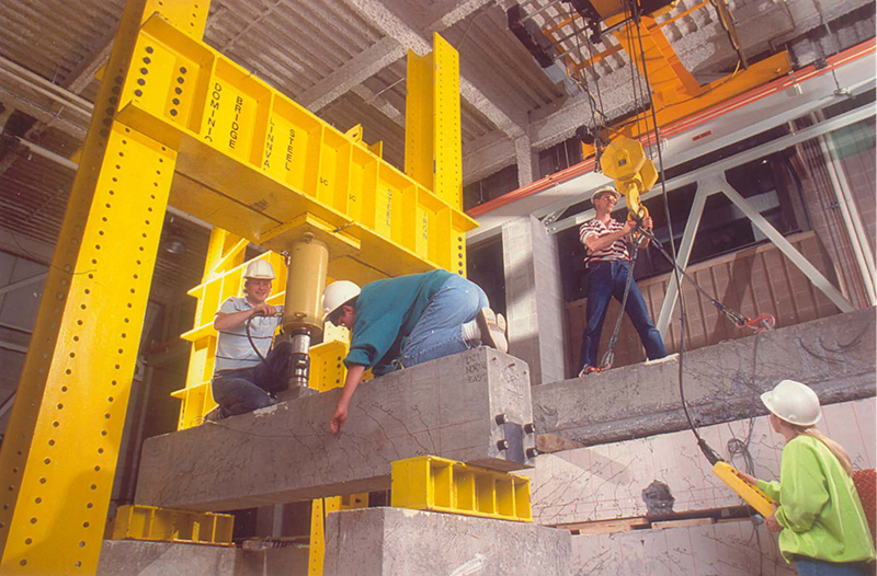 workers on concrete and steel beams inside warehouse