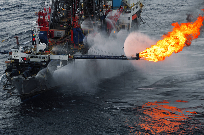 oil rig on the water with fire