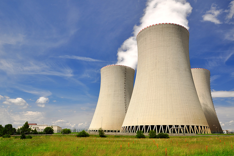 nuclear power plant towers with smoke coming up