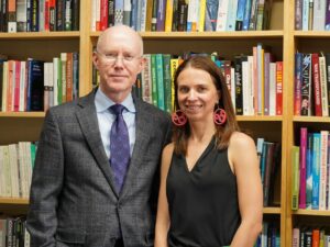 Texas Engineer Kasey Faust smiling in front of bookshelves with her mentor Allen Shearer