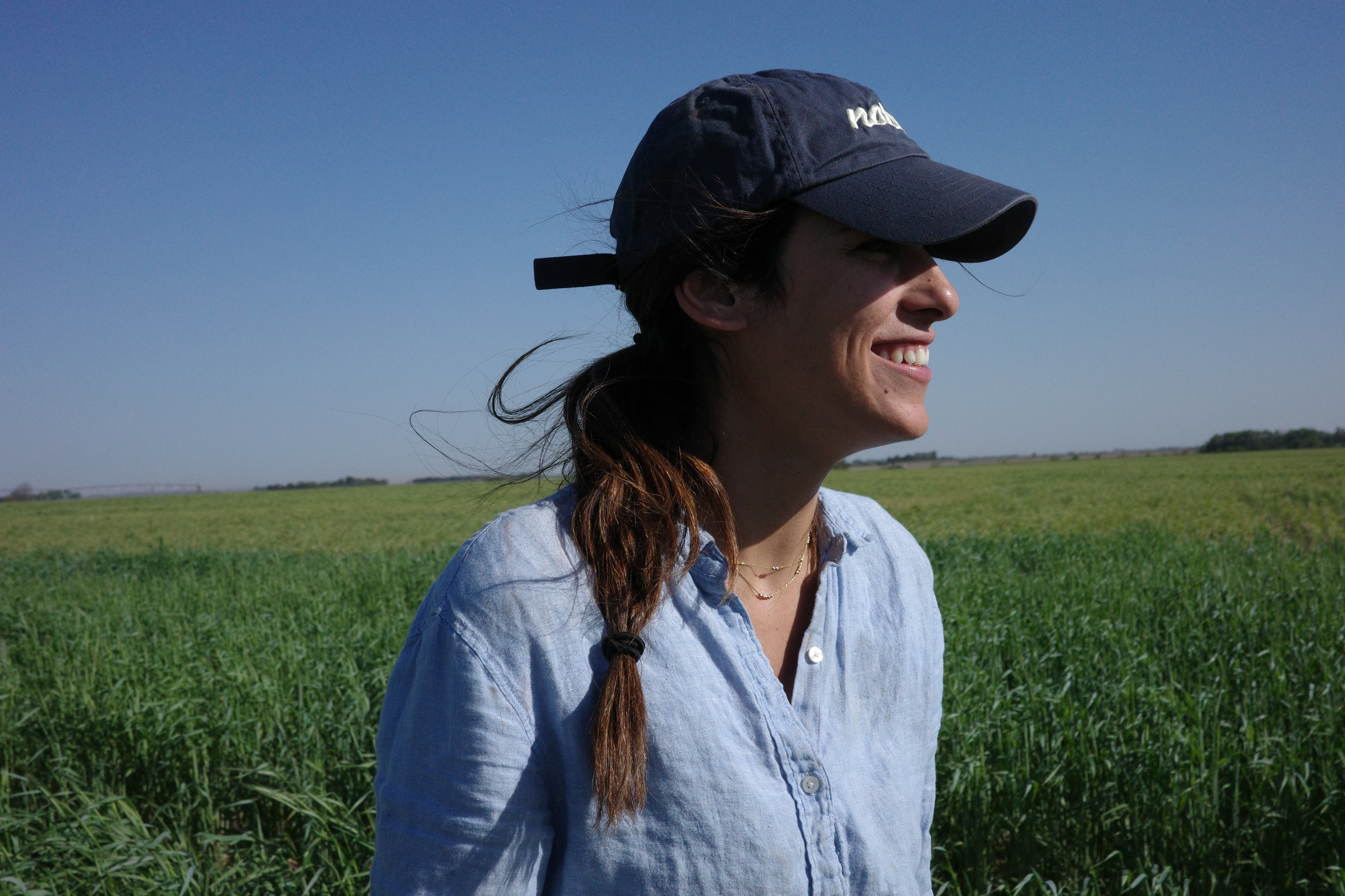 Texas CAE alumna Magi Richani smiling in a farm field